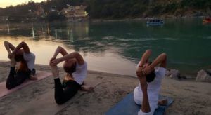 two yoga students practising asana next to the Ganges